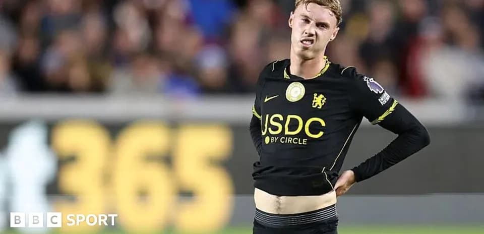 Player in black kit showing discomfort during match