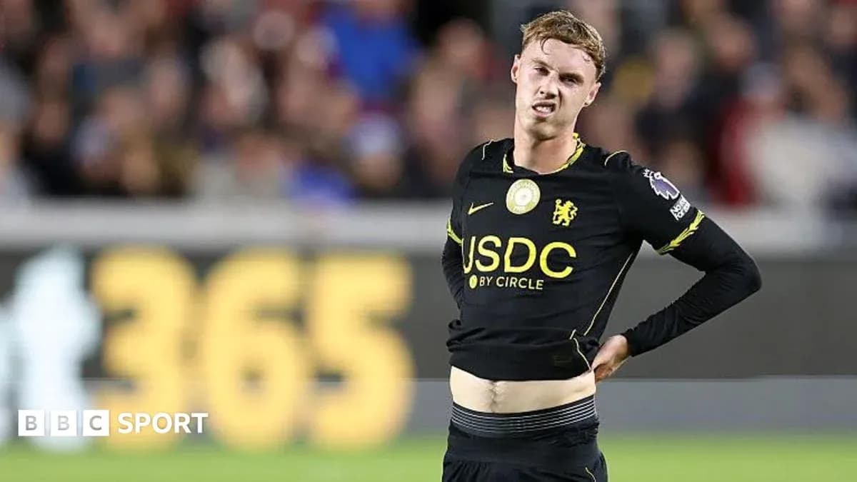 Player in black kit showing discomfort during match