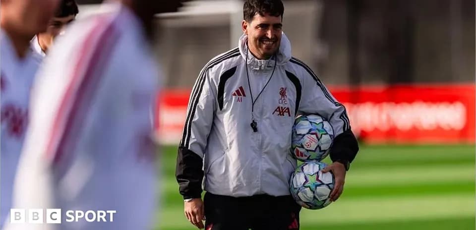 Coach carrying footballs during training session