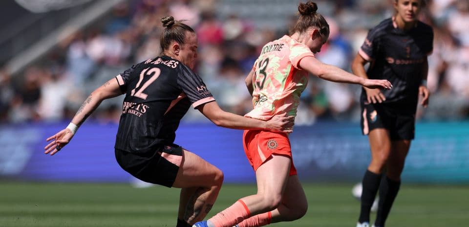 Player tackling opponent during NWSL match