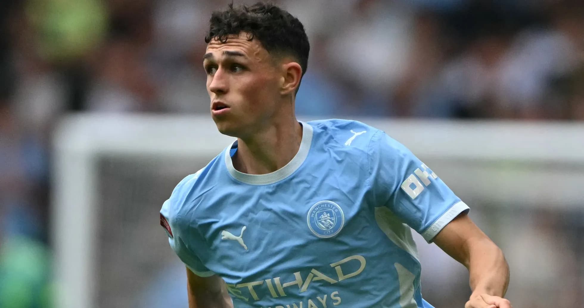 Player in Manchester City kit running on the field