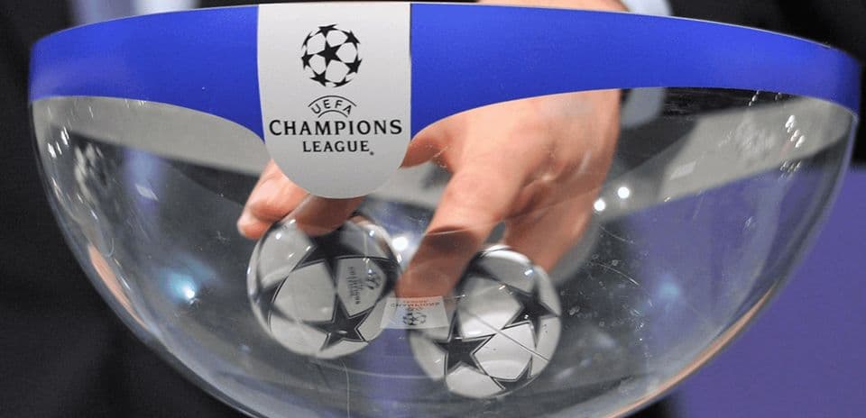 Hand reaching into UEFA Champions League draw bowl