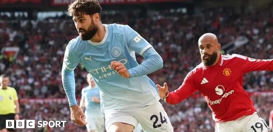 Manchester City player sprinting past Manchester United opponent