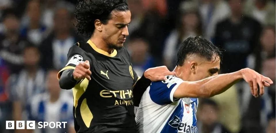 Player in black jersey challenges opponent in white jersey