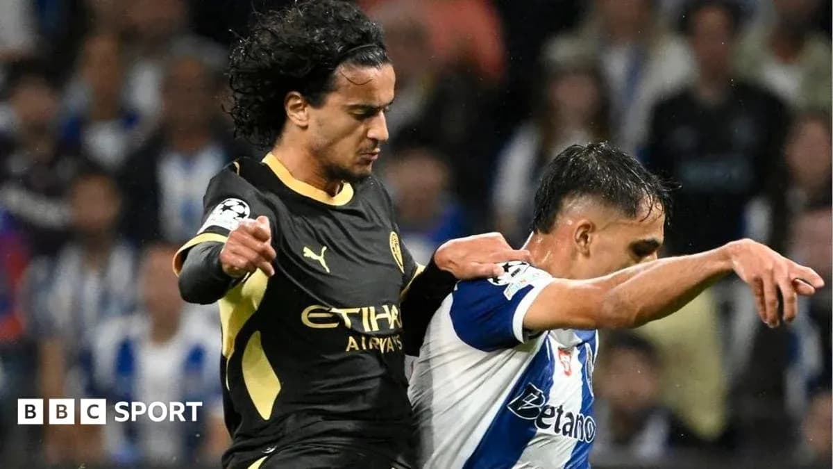 Player in black jersey challenges opponent in white jersey