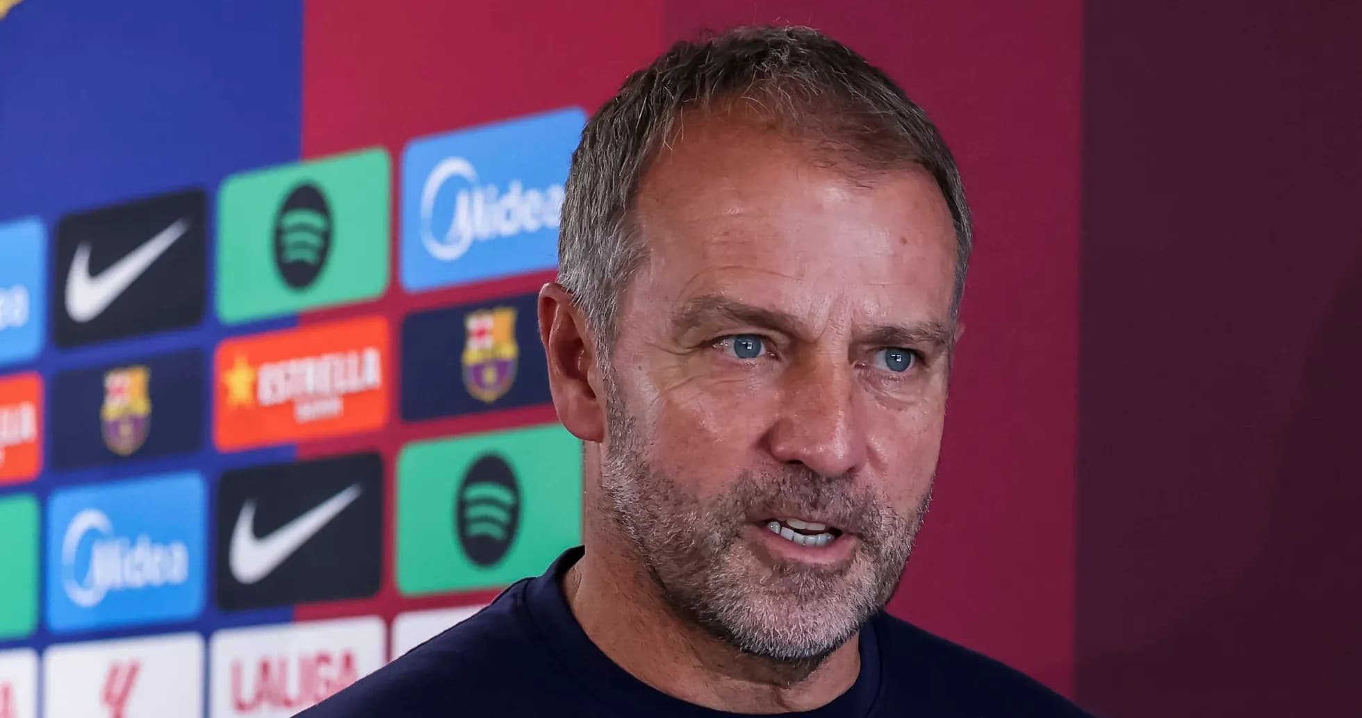 Manager speaking at press conference with club logos