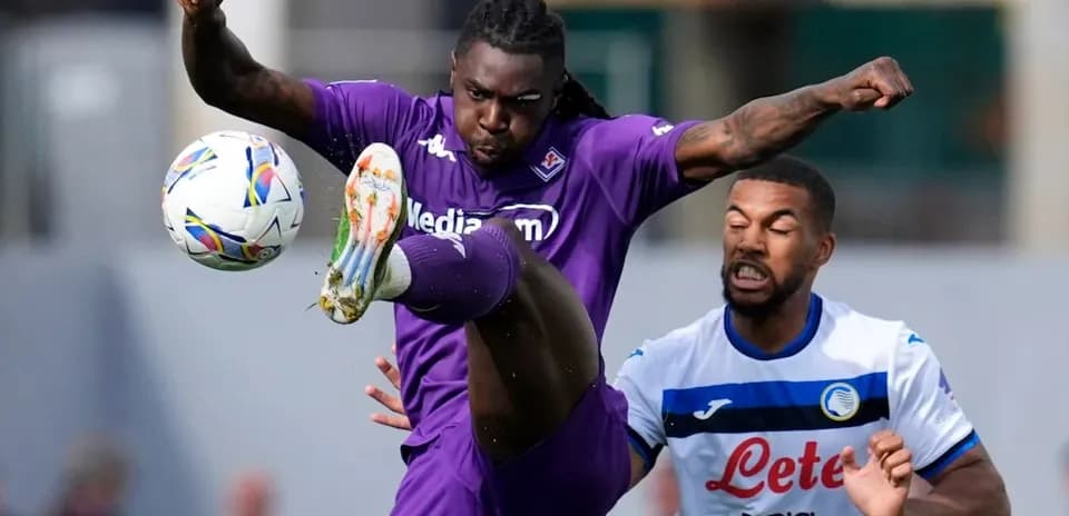 Fiorentina player kicking ball against Atalanta opponent
