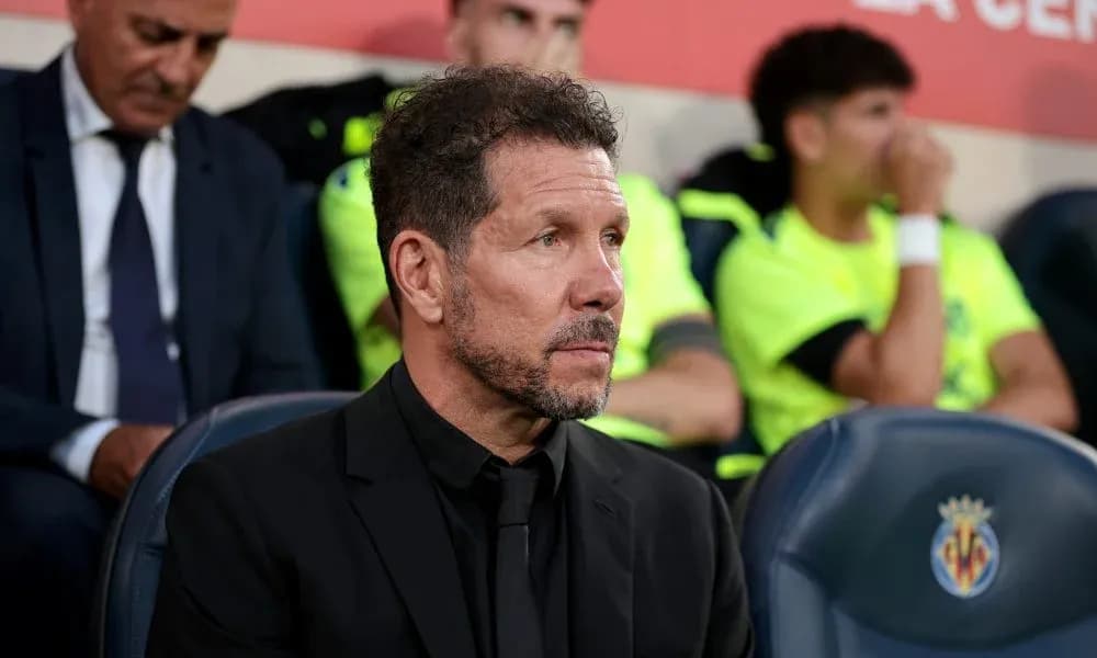 Coach sitting on bench during match at stadium