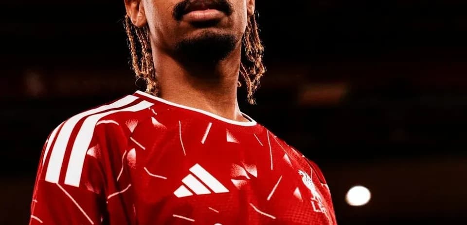 Player posing in Liverpool jersey with braids