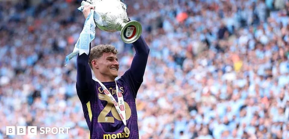 Player celebrating with trophy in stadium