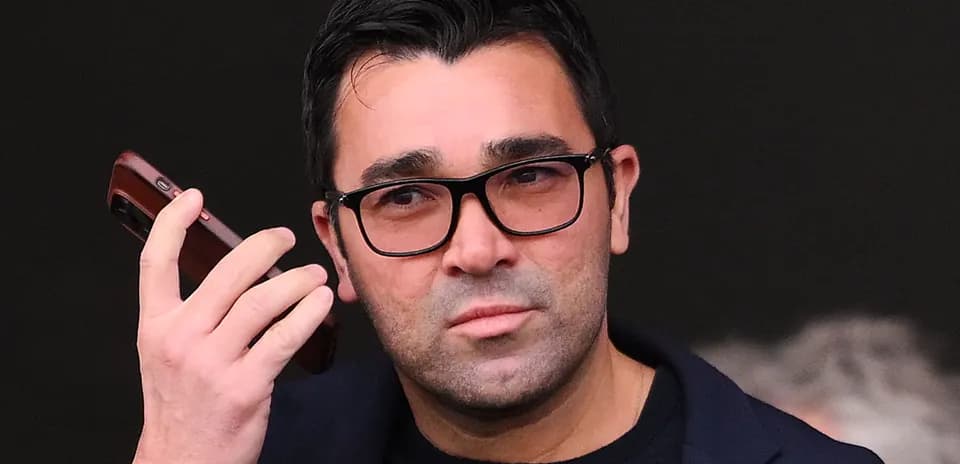 Man holding a phone while looking thoughtfully