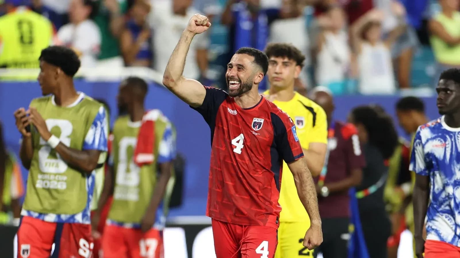 Player celebrating after match with teammates in background