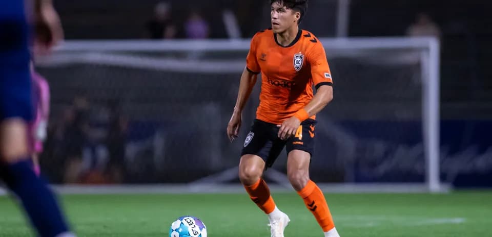 Player in orange jersey with soccer ball