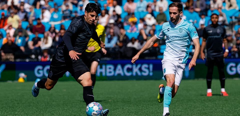 Monterey Bay player dribbling past Loudoun United opponent