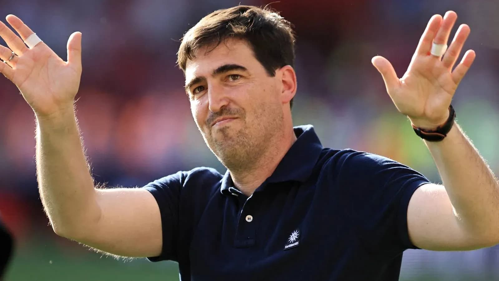 Coach gesturing to fans after the match