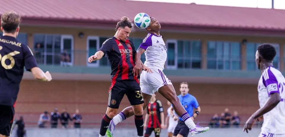 Players contesting a header during match