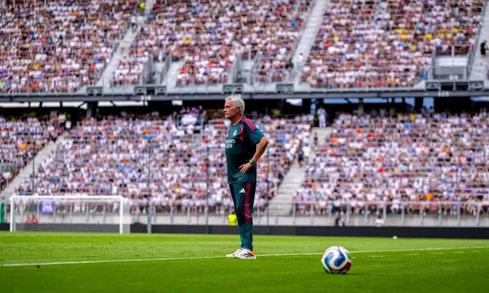 Coach observing match with large crowd in background Coach observing match with large crowd in background