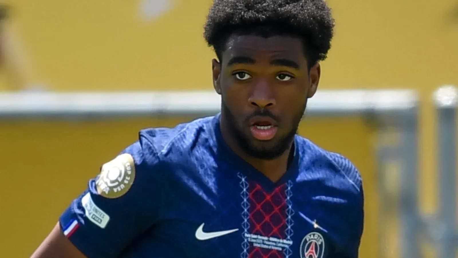 Player in PSG jersey running on the field Player in PSG jersey running on the field