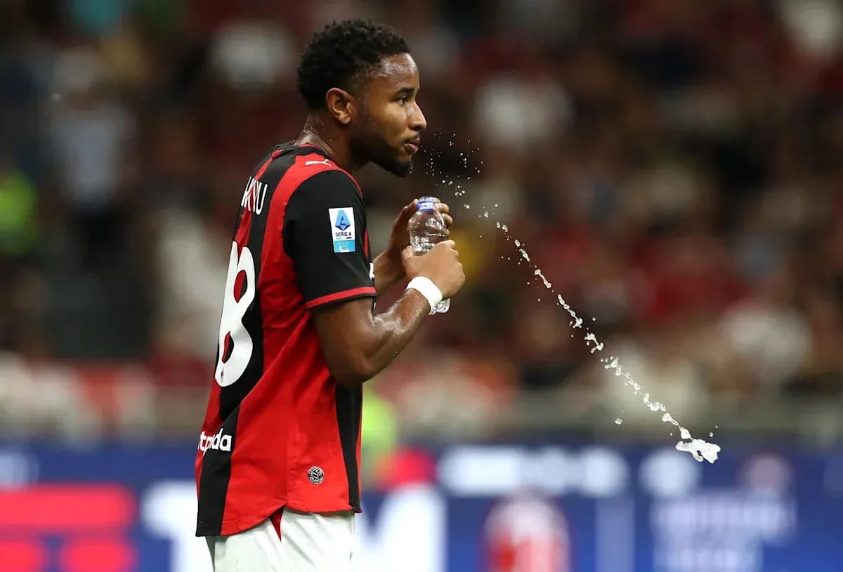 Player spraying water from a bottle on the field Player spraying water from a bottle on the field