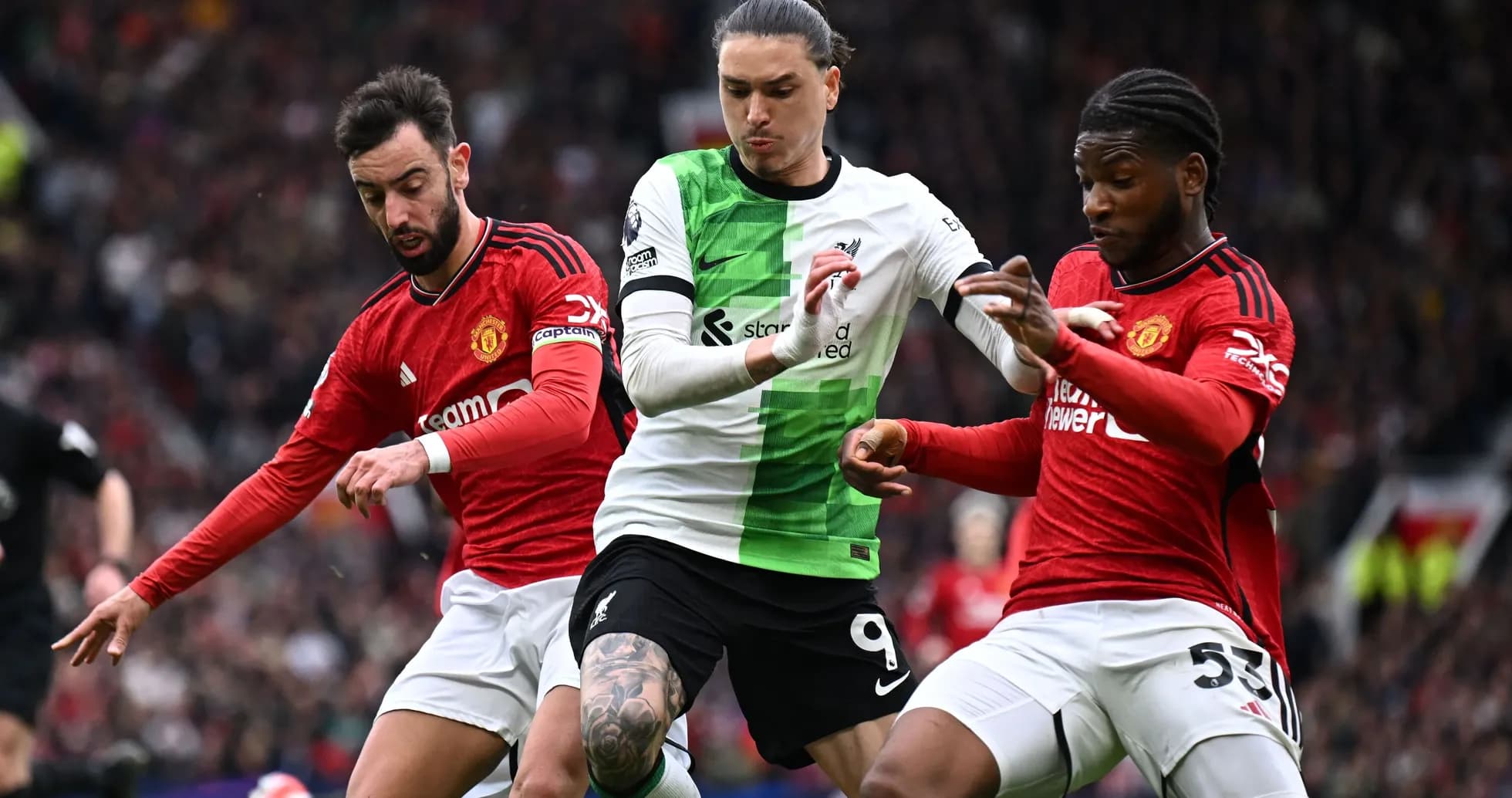 Bruno Fernandes and player challenging Liverpool's striker Bruno Fernandes and player challenging Liverpool's striker