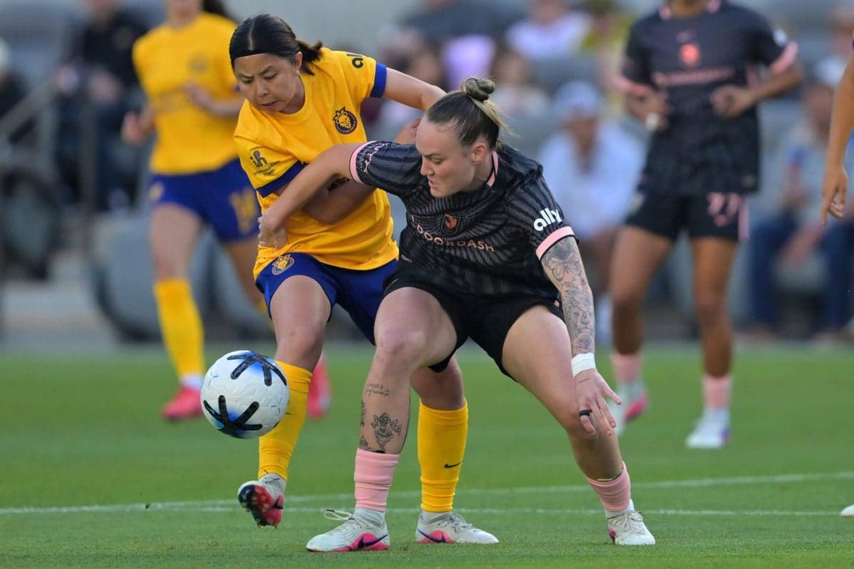Two players competing for the ball in match Two players competing for the ball in match