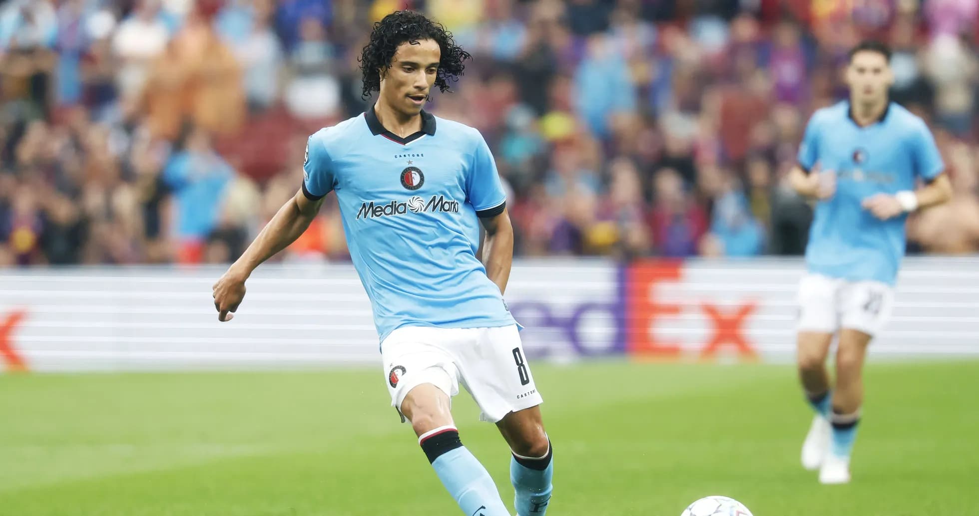 Player in blue kit passing the ball during match Player in blue kit passing the ball during match