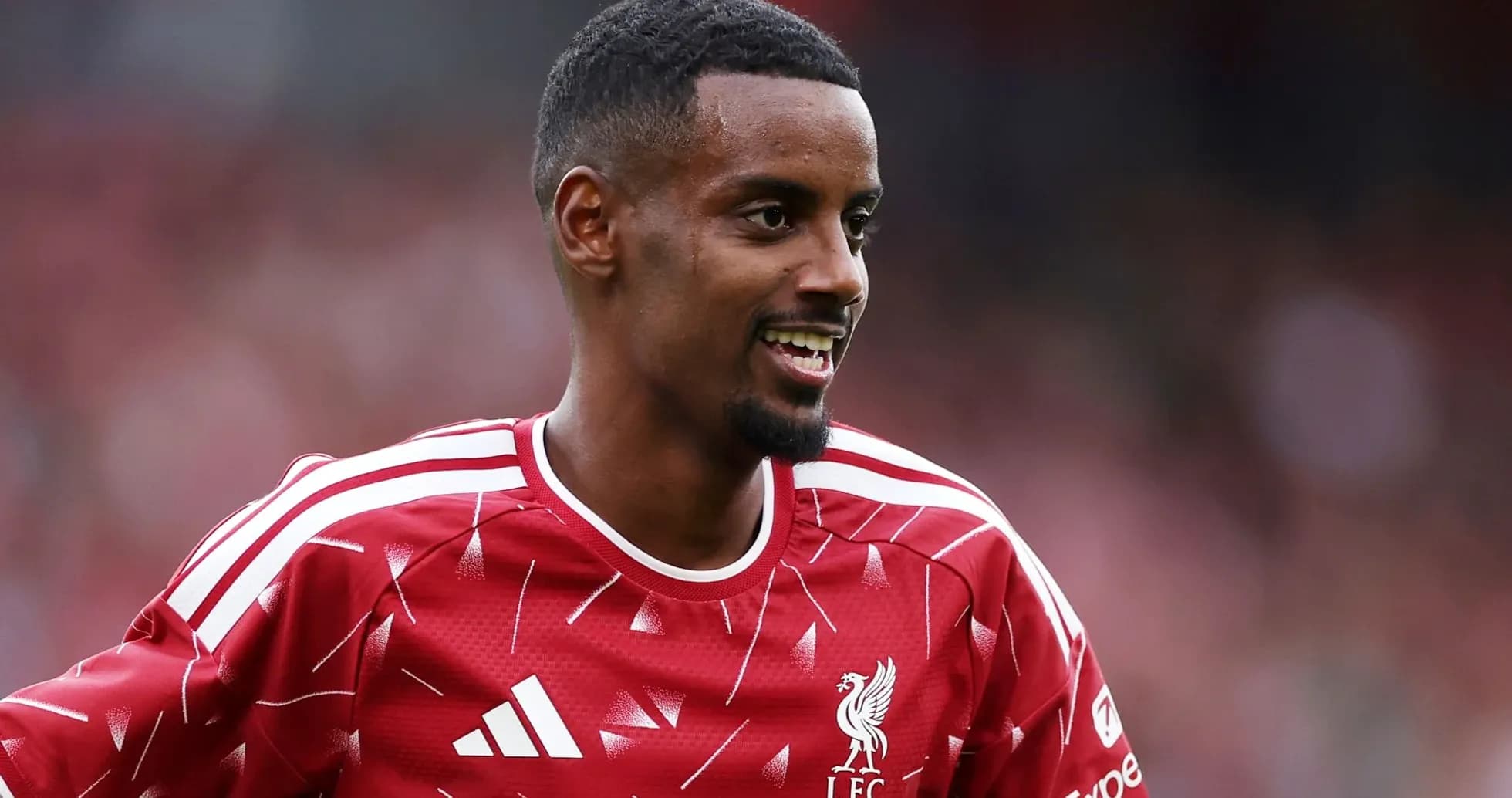 Player in red Liverpool kit smiling during match Player in red Liverpool kit smiling during match