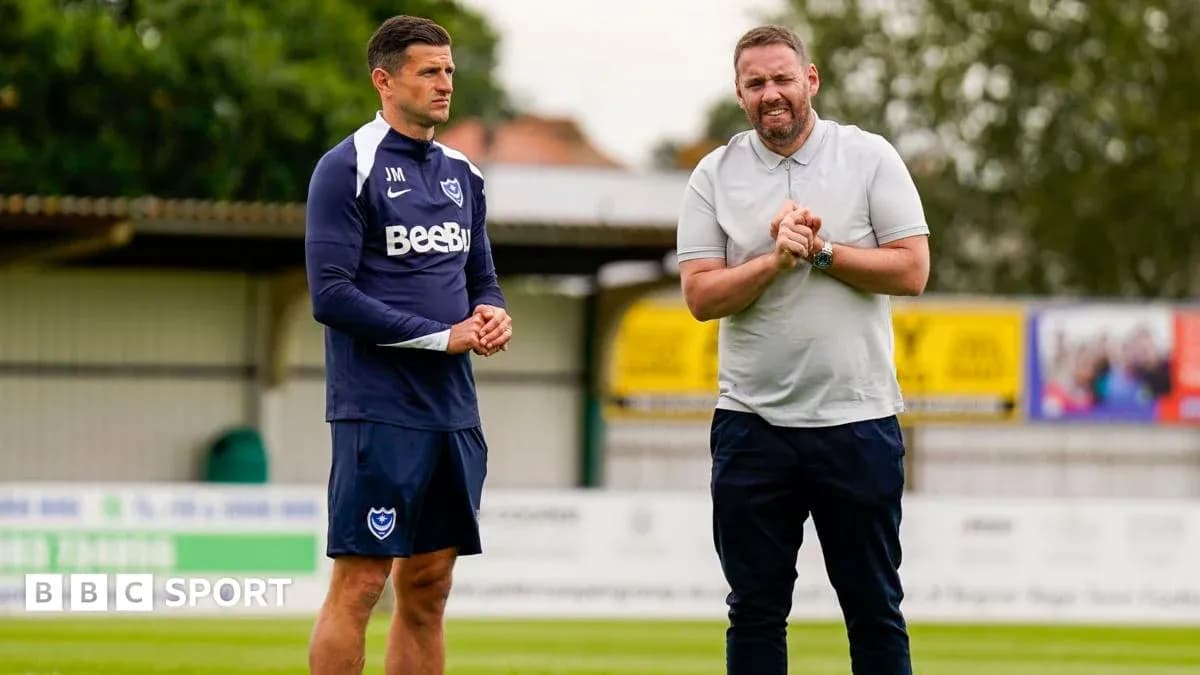 Two men discussing on a football training pitch Two men discussing on a football training pitch
