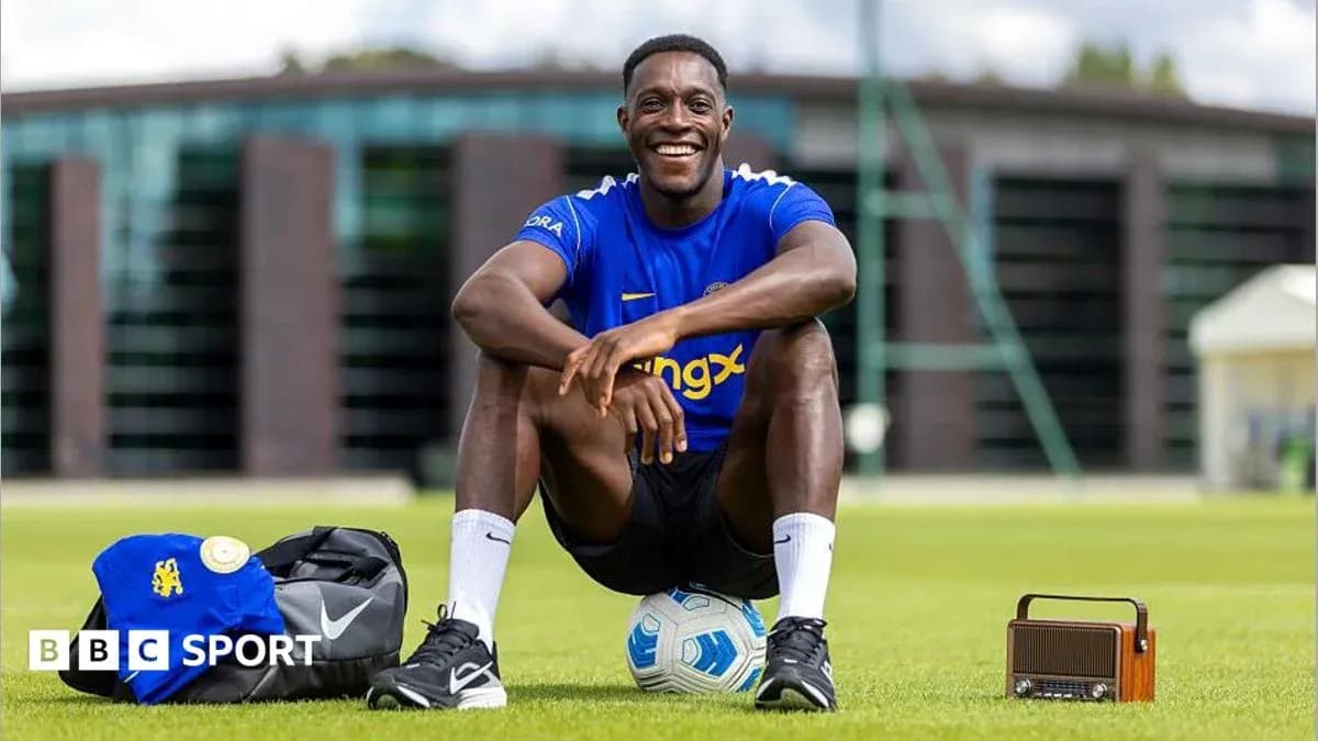 Player sitting on grass with soccer ball and bag Player sitting on grass with soccer ball and bag