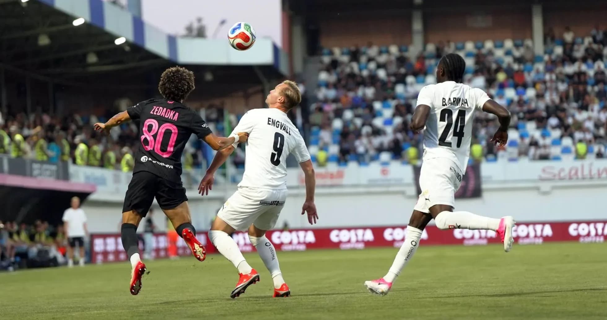 Players competing for the ball in football match Players competing for the ball in football match