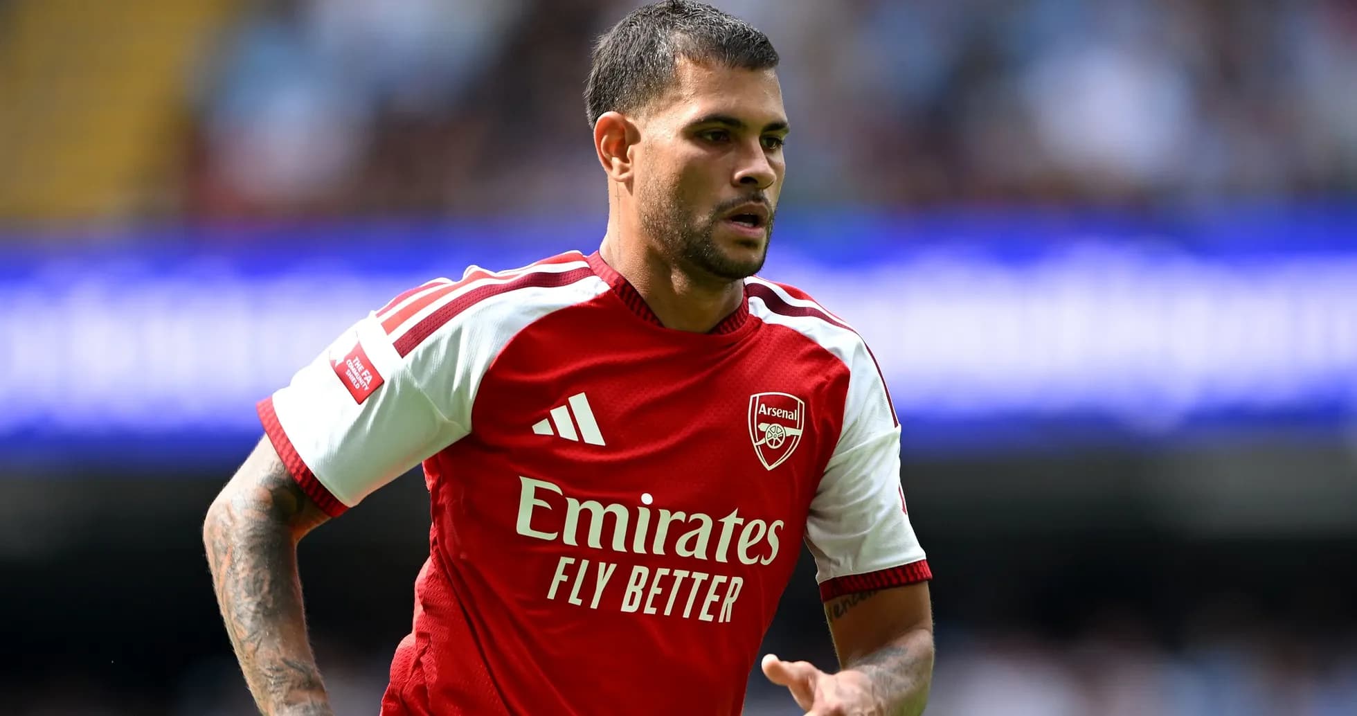 Player in Arsenal kit running on the pitch Player in Arsenal kit running on the pitch
