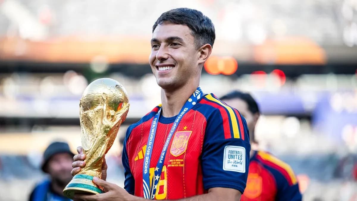 Player holding FIFA World Cup trophy on field Player holding FIFA World Cup trophy on field