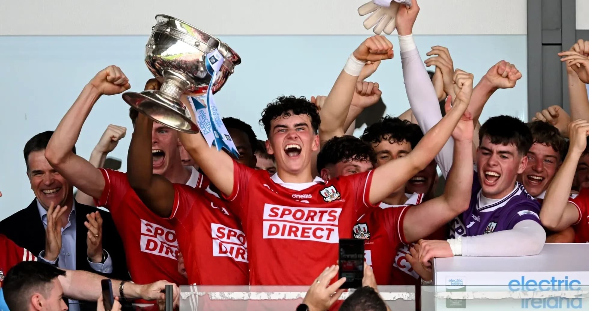 Team celebrating victory with trophy raised high Team celebrating victory with trophy raised high