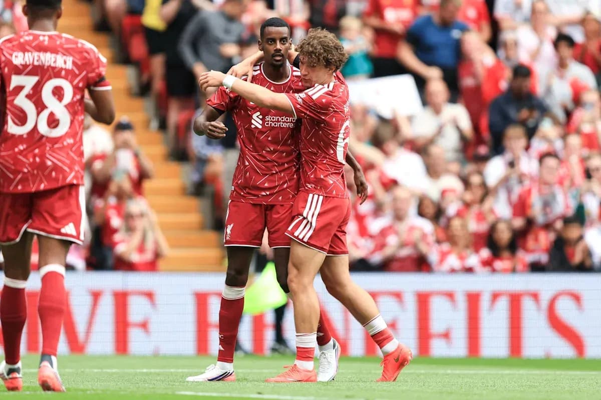 Two Liverpool players celebrating a goal on the pitch Two Liverpool players celebrating a goal on the pitch