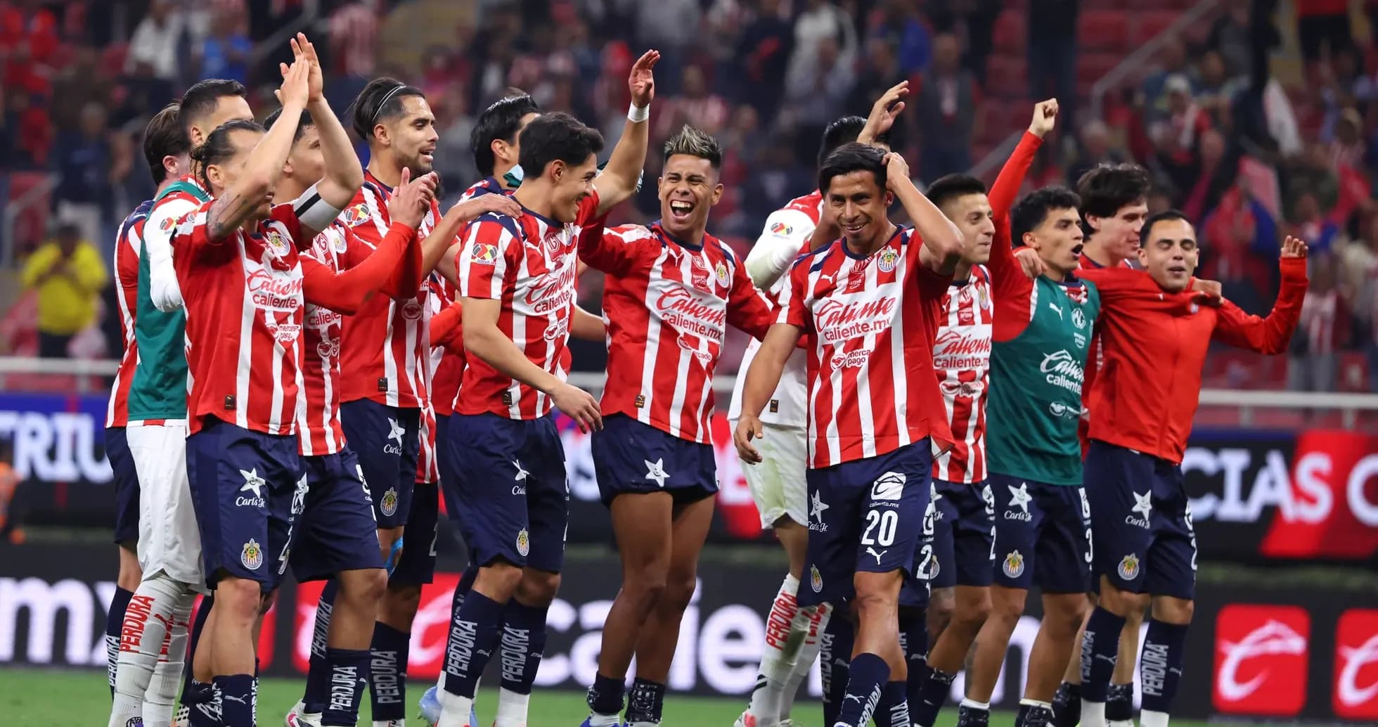 Chivas players celebrating victory on the field Chivas players celebrating victory on the field