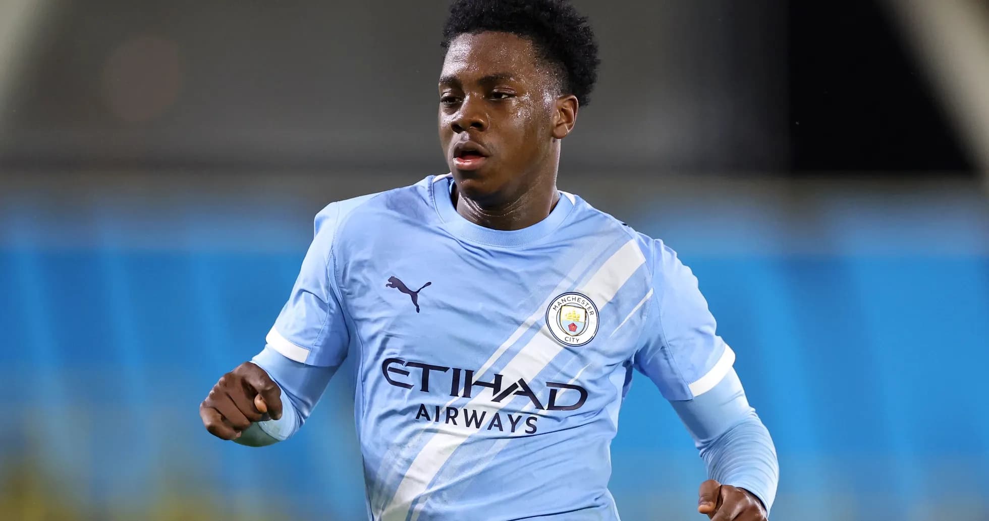 Player in Manchester City kit running on the pitch Player in Manchester City kit running on the pitch