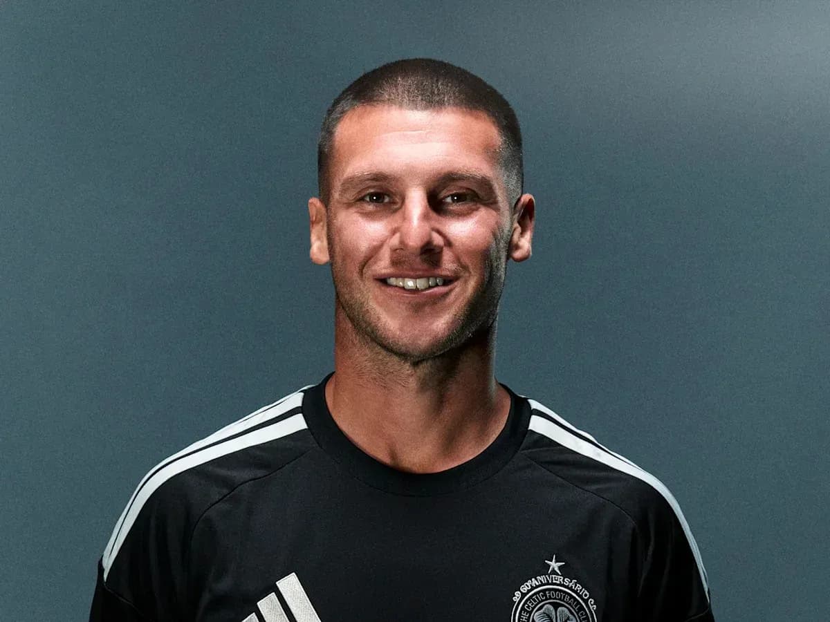 Player smiling in black training kit with stripes Player smiling in black training kit with stripes
