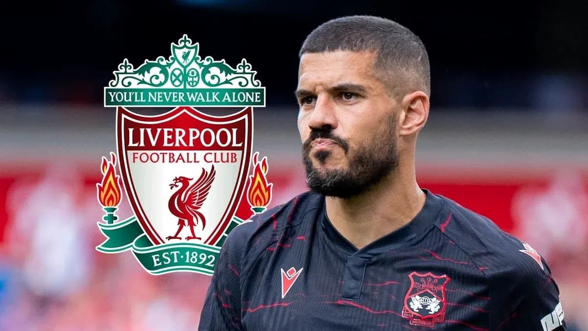 Player in black jersey with Liverpool logo backdrop Player in black jersey with Liverpool logo backdrop