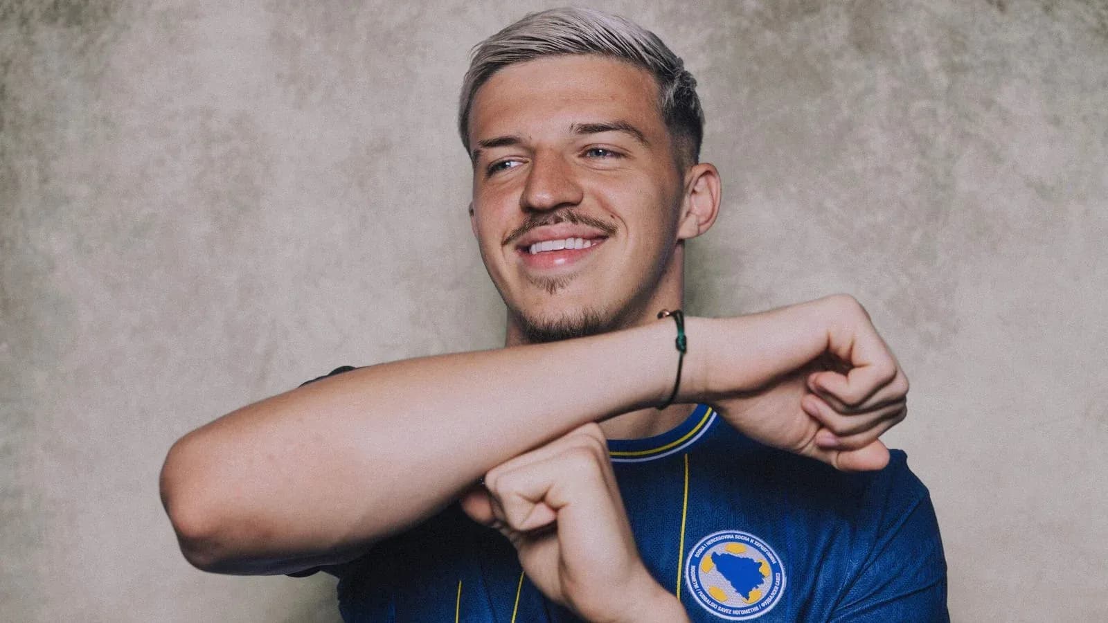 Player posing in national team jersey with smile Player posing in national team jersey with smile