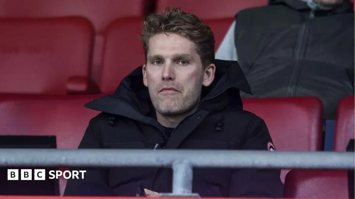 Person seated in stadium wearing a black coat Person seated in stadium wearing a black coat