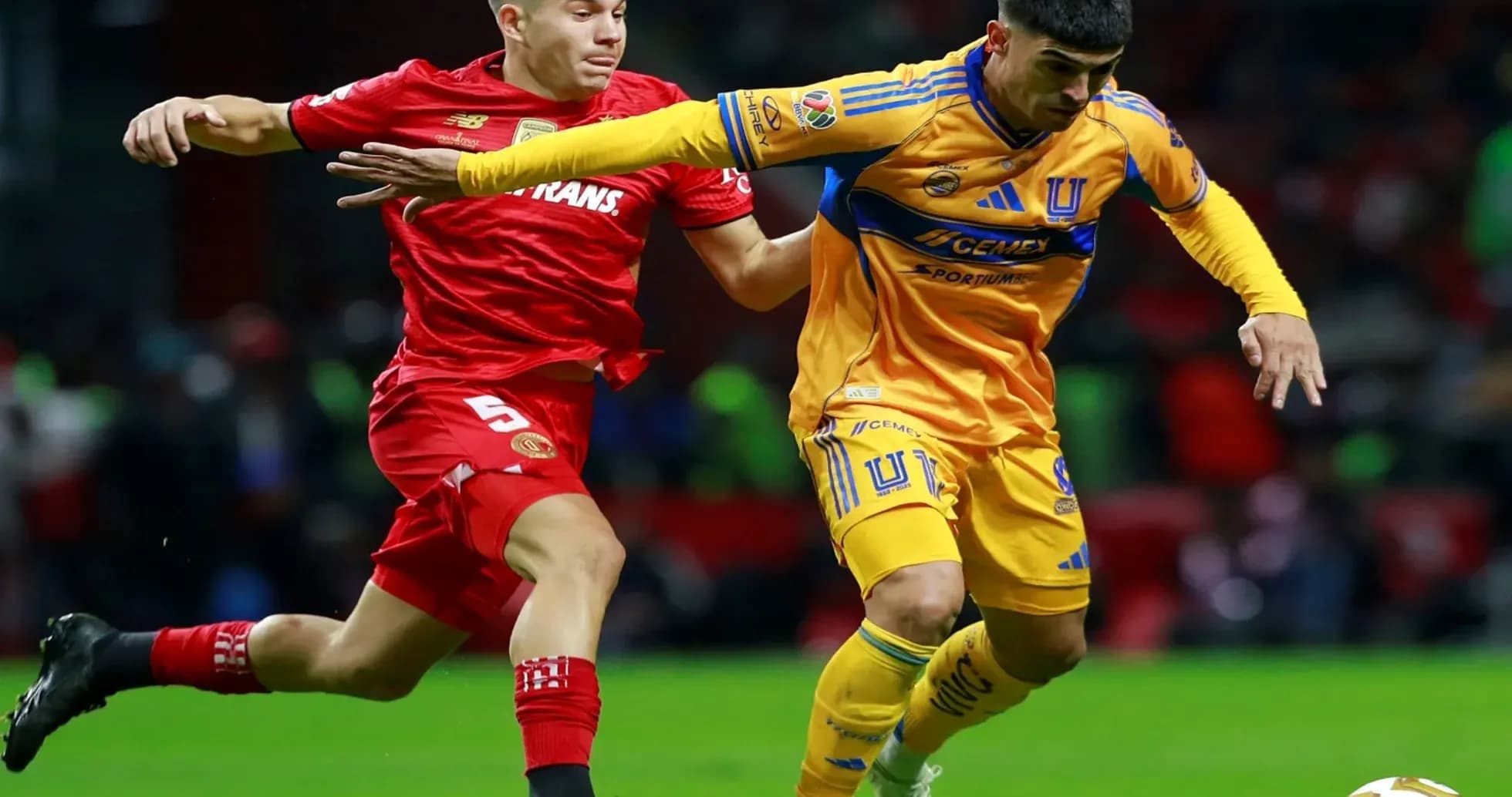 Toluca player challenging Tigres UANL player Toluca player challenging Tigres UANL player