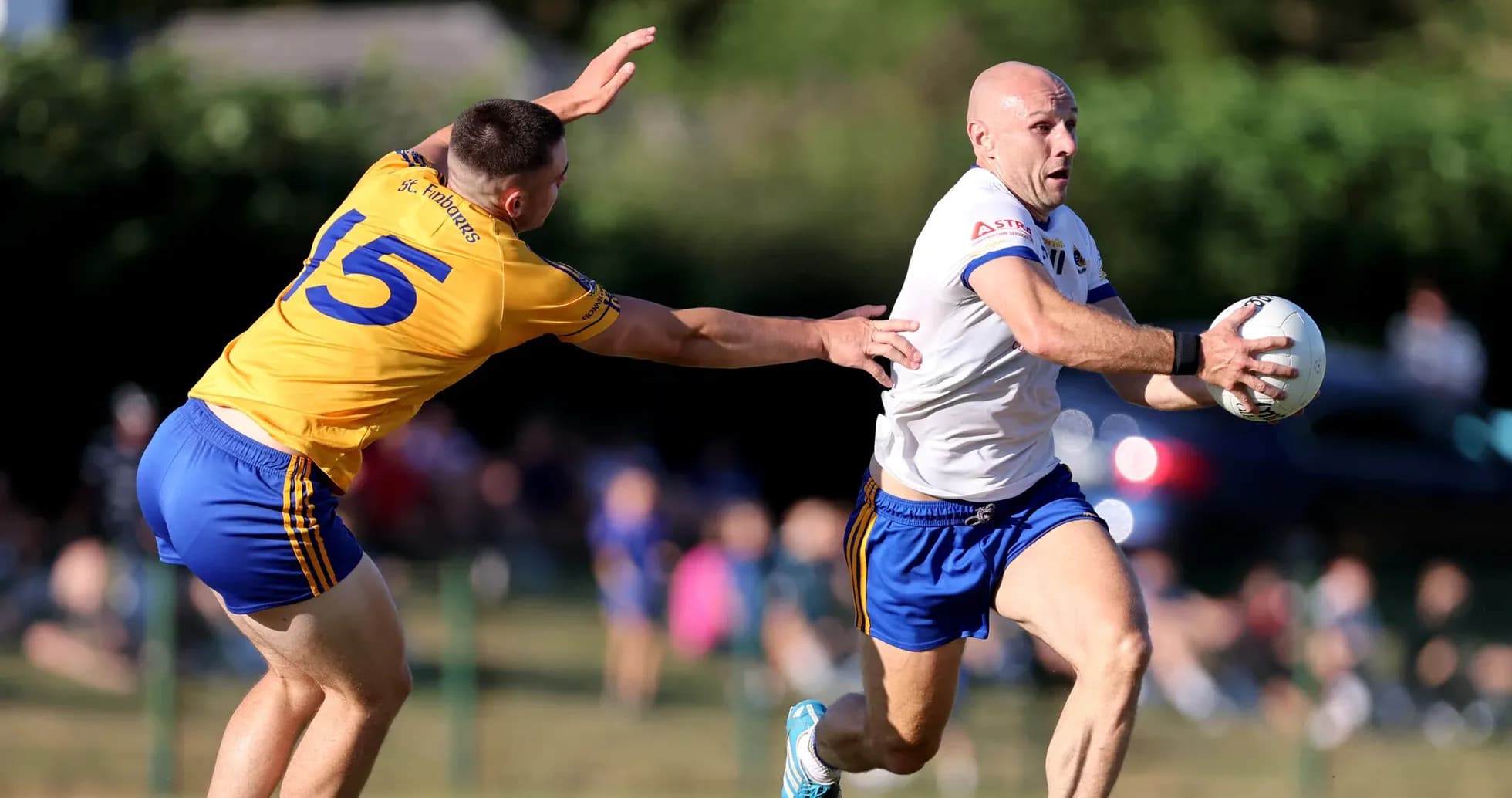 Player in white running with ball, opponent reaching out Player in white running with ball, opponent reaching out