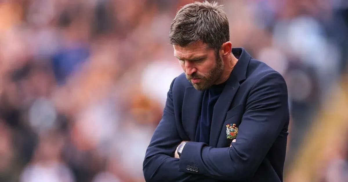 Coach with arms crossed, looking down during match Coach with arms crossed, looking down during match