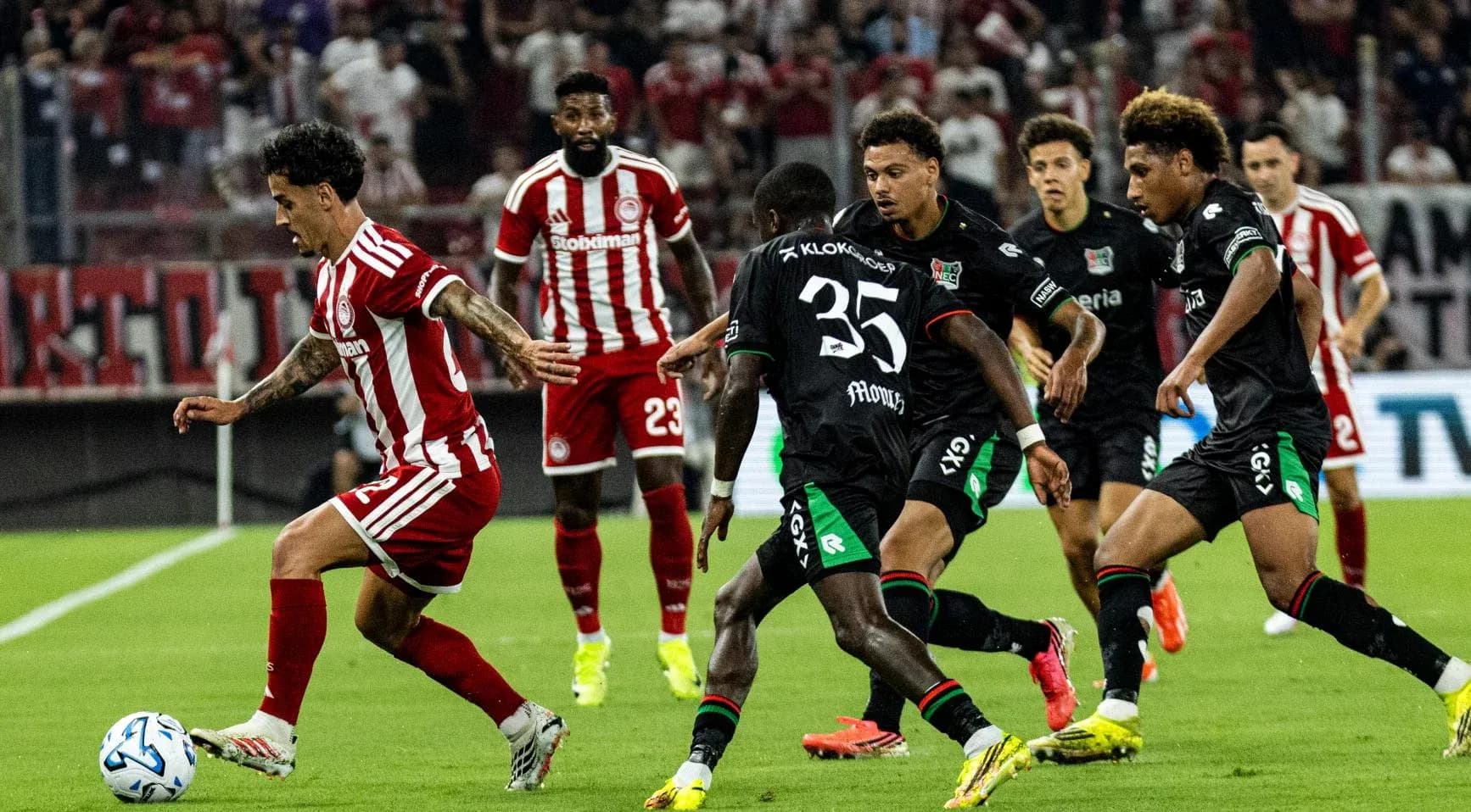 Olympiakos player dribbling past NEC defenders Olympiakos player dribbling past NEC defenders