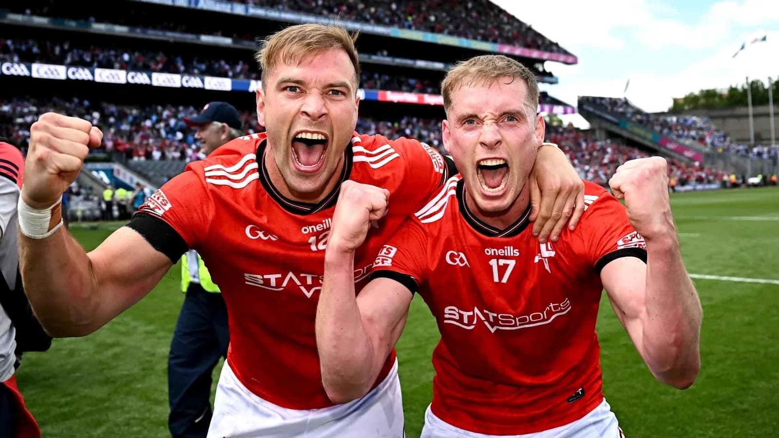 Two players celebrating in red jerseys on field Two players celebrating in red jerseys on field