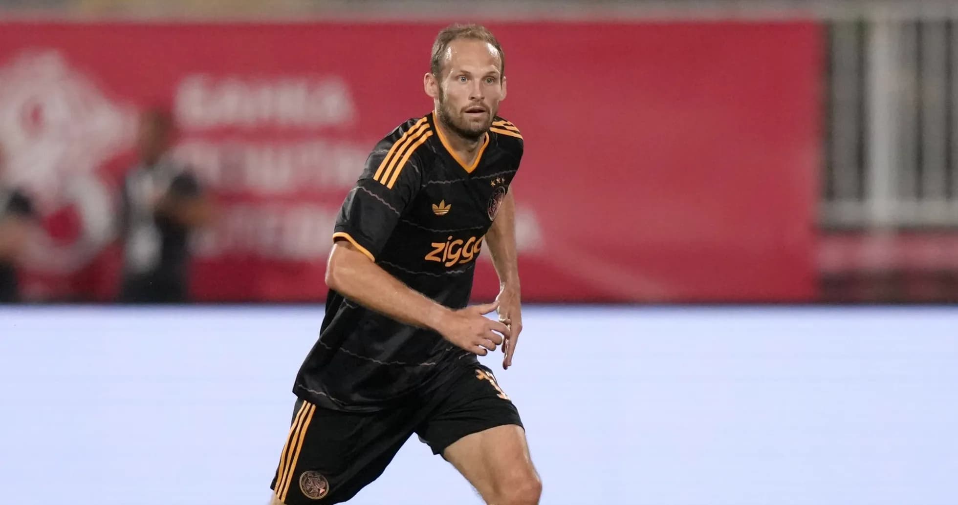 Player in Ajax uniform running on the field Player in Ajax uniform running on the field