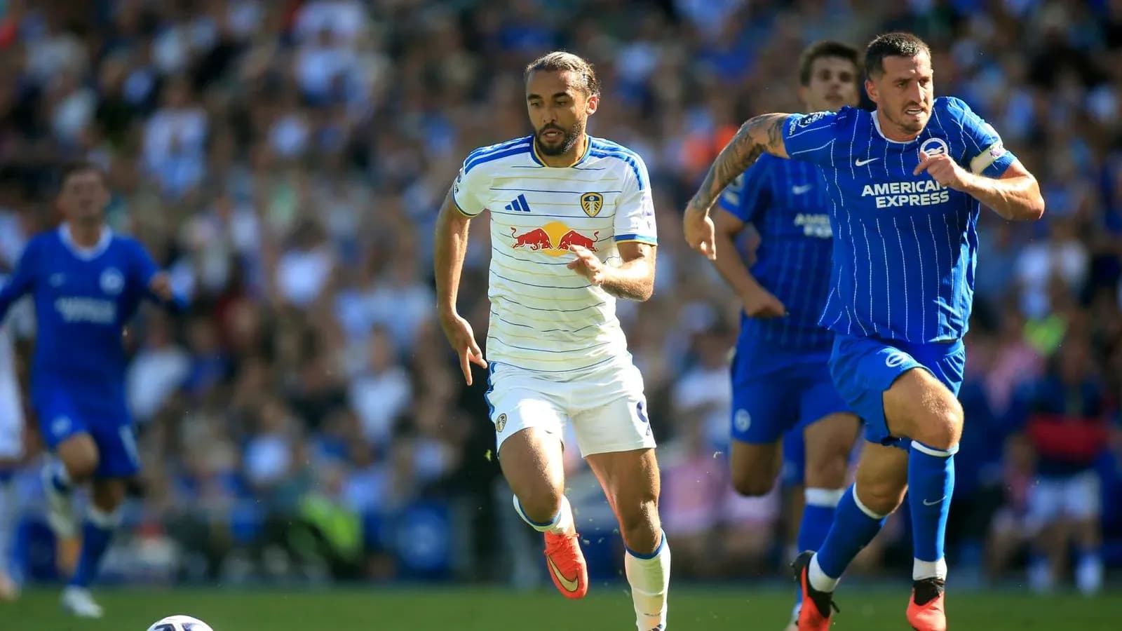 Leeds player sprinting with Brighton player pursuing Leeds player sprinting with Brighton player pursuing