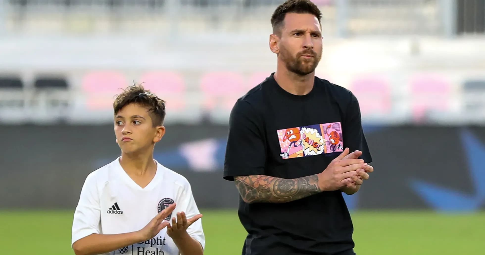 Lionel Messi and a young boy clapping on field Lionel Messi and a young boy clapping on field