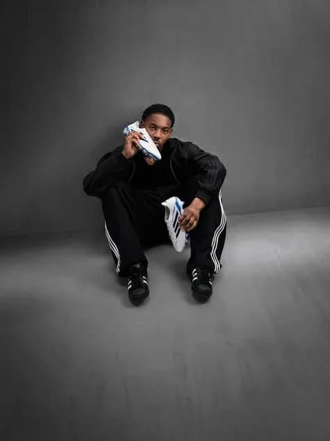 Athlete sitting with soccer shoe in hand Athlete sitting with soccer shoe in hand