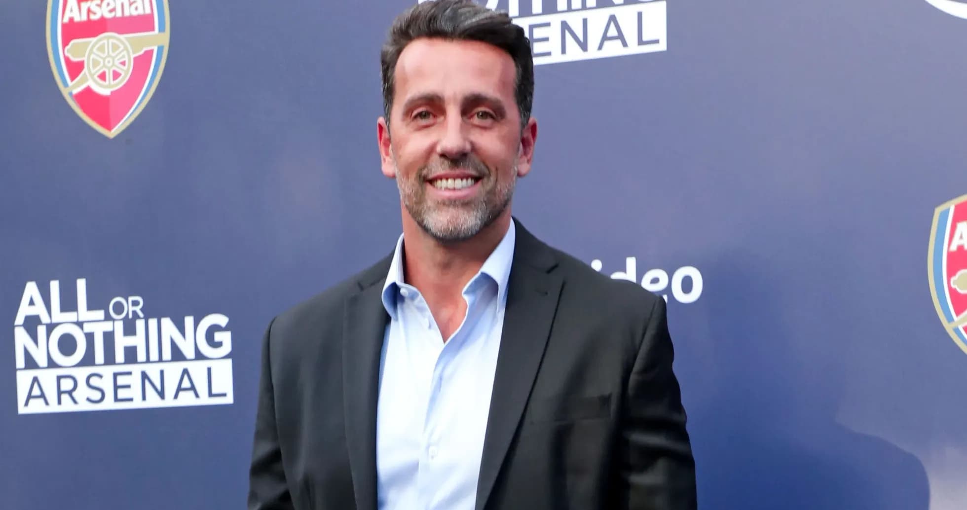 Man in suit smiling at promotional event Man in suit smiling at promotional event